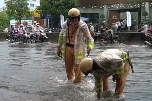 Video: CSGT lội nước giúp dân khơi miệng cống chống ngập