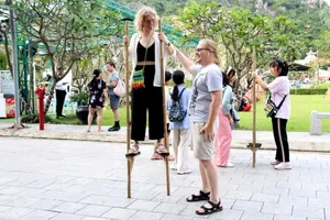 Video: Du khách nước ngoài thích thú trải nghiệm gói bánh tét, đi cà kheo