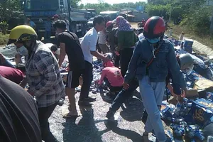Người dân giúp tài xế gom hàng trăm thùng bia đổ ra đường