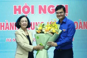 Bà Trương Thị Mai - ủy viên Bộ Chính trị, bí thư Trung ương Đảng, trưởng Ban Tổ chức Trung ương - trao hoa chúc mừng tân Bí thư thứ nhất Trung ương Đoàn Bùi Quang Huy - Ảnh: TTO
