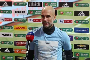Pep Guardiola mặc chiếc áo in hình Colin Bell và dòng chữ "huyền thoại Bell". ẢNH: REX