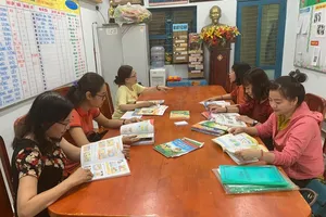 Giáo viên trường Tiểu học Nguyễn Thị Minh Khai, quận Gò Vấp nghiên cứu các bộ sách giáo khoa lớp 1. Ảnh: NTCC