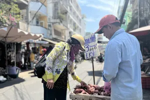 Người dân mua khoai lang Nhật bán ở chợ. Ảnh: TÚ UYÊN
