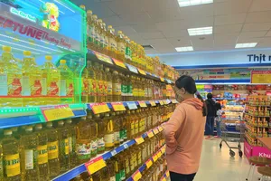 Người tiêu dùng mua hàng hóa ở siêu thị Ảnh: TÚ UYÊN