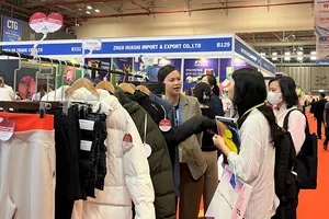 Khách hàng tìm hiểu sản phẩm thời trang tại một triển lãm dệt may tại TP.HCM. Ảnh: TÚ UYÊN