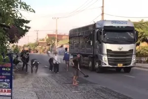 Chở nhựa đường rơi vãi đầy quốc lộ, lái xe ben bị bắt dọn sạch 