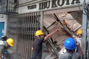 Công nhân kiểm tra một cửa hàng hư hại sau trận động đất ở khu vực Cianjur, tỉnh Tây Java (Indonesia) ngày 21-11. Ảnh: CNN