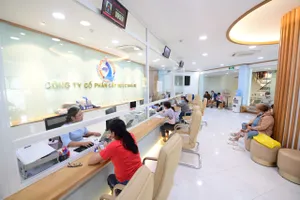 Nhân viên Công ty CP Cấp nước Nhà Bè hướng dẫn khách hàng sử dụng app CSKH SAWACO. Ảnh: ĐÀO TRANG