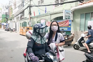 Phụ huynh TP.HCM đưa con đi thi che chắn kín mít để chống nóng. Ảnh: Phan Yên 