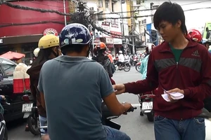 Phát tờ rơi và những giao lộ tràn ngập rác