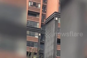 Ông cõng cháu leo bên ngoài tòa nhà để trốn khỏi đám cháy