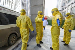 Nhân viên y tế mặc quần áo bảo hộ và khử trùng phòng nhiễm virus Corona. Ảnh: AP