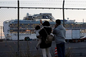 Người thân vẫy tay và nói chuyện qua điện thoại với khách trên tàu Diamond Princess đậu tại cảng Daikoku Pier Cruise ở Yokohama (Nhật). Ảnh: REUTERS