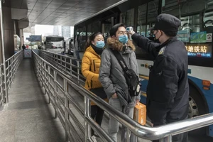 Hành khách được kiểm tra thân nhiệt trước khi lên xe ở Thượng Hải. Ảnh: REUTERS