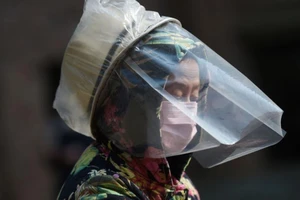 Một phụ nữ ở Vũ Hán dùng đồ bảo hộ khuôn mặt tạm thời để chống lây nhiễm COVID-19. Ảnh: REUTERS