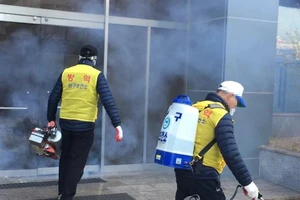 Các quan chức kiểm dịch khử trùng một nhà thờ Shincheonji ở phía đông nam thành phố Daegu hôm 23-2. Ảnh: YONHAP