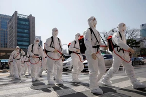 Các binh sĩ Hàn Quốc trong trang phục bảo hộ đi trên đường phố Daegu hôm 2-3 - Ảnh: REUTERS