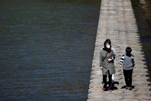 Một gia đình đeo khẩu trang đang đi qua một con đường mòn ở quận Cheongdo, Gyeongsang Bắc (Hàn Quốc). Ảnh: REUTERS