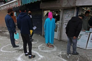 Người dân Ấn Độ buộc phải đứng trong từng ô vẽ sẵn để giữ khoảng cách khi đến mua thuốc tại hiệu thuốc ở thành phố Srinagar, bang Kashmir hôm 26-3. Ảnh: GETTY