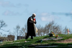 Một mục sư đeo khẩu trang đi vào nghĩa trang Green Wood, ở thành phố New York, Mỹ. Ảnh: REUTERS