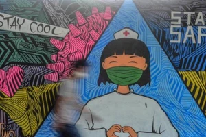 Một bức tranh tường vẽ một y tá tuyến đầu chống COVID-19 ở quận Ciamis, thuộc tỉnh Tây Java, Indonesia. Ảnh: REUTERS
