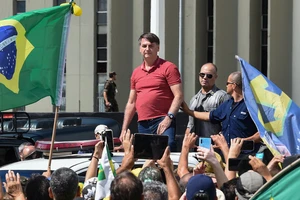 Tổng thống Brazil Jair Bolsonaro cùng một nhóm người biểu tình trước tổng hành dinh quân đội Brazil ở thủ đô Brasilia. Ảnh: AFP