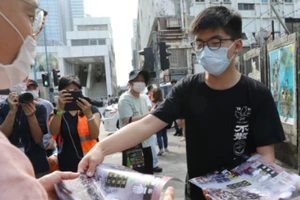 Hoàng Chi Phong đang phát tờ rơi cho người dân ở khu Quan Đường. Ảnh: SCMP