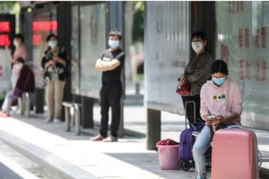 Người dân Vũ Hán đang chờ xe buýt. Ảnh: AFP