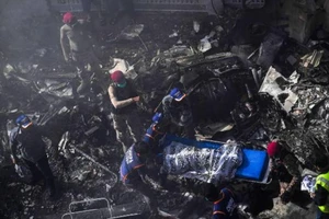 Đội cứu hộ đưa thi thể các nạn nhân ra khỏi hiện trường tai nạn. Ảnh: AFP