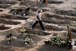 Một người đào mộ đi ngang qua những ngôi mộ làm sẵn cho bệnh nhân tử vong vì COVID-19, tại một nghĩa trang ở TP Acapulco, Mexico. Ảnh: REUTERS