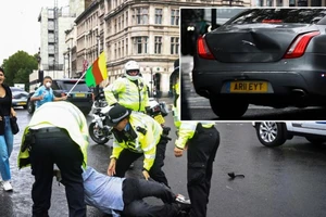 Các sĩ quan cảnh sát bắt giữ người biểu tình gần Tòa nhà Quốc hội sau khi ông này lao vào đoàn xe thủ tướng. Ảnh nhỏ cho thấy chiếc xe chở thủ tướng bị móp phần đuôi sau vụ va chạm. Ảnh: REUTERS/RT