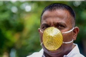 Doanh nhân Kurhade đeo khẩu trang vàng. Ảnh: AFP