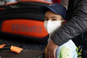 Một cậu bé mang khẩu trang khi đang đứng làm thủ tục ở sân bay quốc tế Dulles, thủ đô Washington, D.C, Mỹ. Ảnh: REUTERS/ALARABIYA