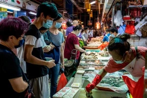 Nhiều người đeo khẩu trang khi đang đi chợ cá ở Hong Kong. Ảnh: AP/CNN