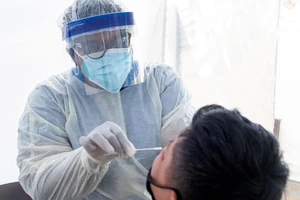 Nhân viên y tế lấy mẫu xét nghiệm COVID-19 cho một học sinh tại TP Los Angeles, bang California (Mỹ) ngày 24-7. Ảnh: VALERIE MACON/AFP/GETTY/CNN