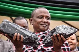 Ông Laizer cầm hai khối đá tanzanite mà ông khai thác được vào tháng 6-2020. Ảnh: AFP/GETTY/USA TODAY