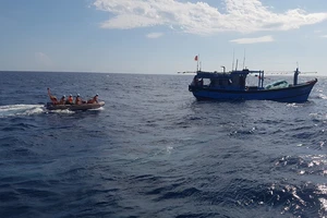Lực lượng cứu nạn hàng hải tiếp cận tàu cá có ngư dân đang nguy kịch. Ảnh: Danang MRCC