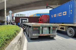 Container ôm cua ép hai cô gái đi xe máy văng vào lề ở quận 7