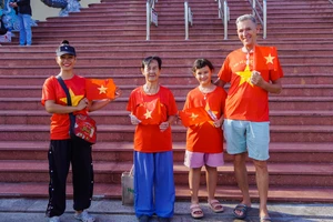 Khách quốc tế diện áo cờ đỏ sao vàng check-in tại khu vui chơi dịp lễ 30-4