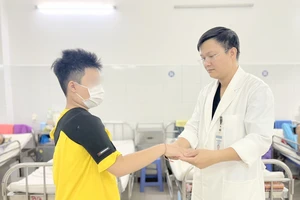 Bác sĩ thăm khám cho bệnh nhân 10 tuổi sau phẫu thuật do đột quỵ. Ảnh: MT.