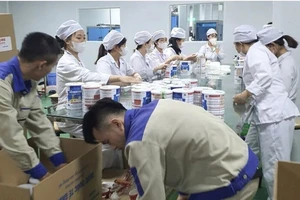 Công nhân đóng hộp thành phẩm sữa bột tại cơ sở sản xuất, chuẩn bị tung ra thị trường. Ảnh CA