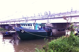 Triều cường làm xà lan kẹt dưới một cây cầu ở Cần Thơ