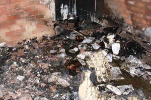 Cảnh sát mang bình gas ra khỏi nhà trọ bốc cháy