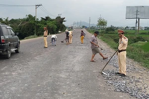 Cả chục cảnh sát dọn đá dăm do xe tải rải trên đường