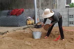 Người dân đưa cát lên nóc chằng chống nhà
