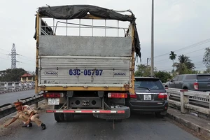 Xe tải kẹp ô tô 7 chỗ vào thành cầu