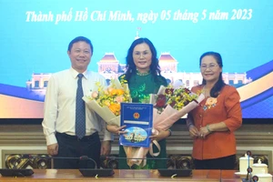 Chủ tịch HĐND TP.HCM Nguyễn Thị Lệ, Phó Chủ tịch UBND TP.HCM Dương Anh Đức trao hoa, quyết định cho bà Lê Thụy Mỵ Châu. Ảnh: LÊ THOA