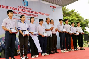 Ông Trương Hòa Bình, nguyên Phó Thủ tướng thường trực Chính phủ, Chủ tịch danh dự của chương trình, cùng ông Mai Ngọc Phước, Tổng Biên tập báo Pháp Luật TP.HCM, trao học bổng cho con em ngư dân tỉnh Bến Tre.