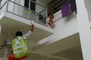 Kinh hãi cảnh em bé kẹt đầu vào chấn song tòn teng trên không