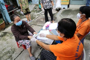 Người dân khu phố 1 phường 5, quận Phú Nhuận, TP.HCM nhận hỗ trợ đợt 3. Ảnh: HOÀNG GIANG